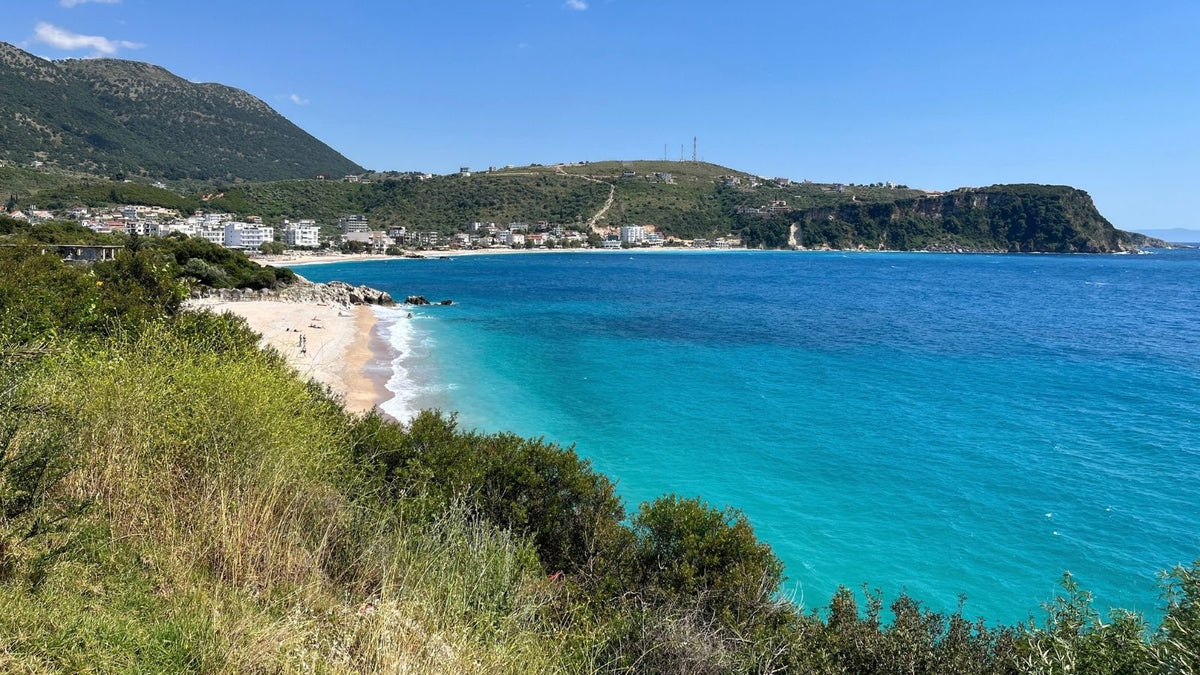 Türkisblaue Küstenbucht bei Himara an der albanischen Riviera – eine Etappe der Vanreise mit Hund durch Albanien.